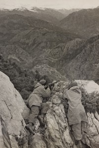 Partigiani appostati sullo sperone di una roccia durante la Seconda Guerra Mondiale.