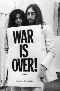 John Lennon (1940 - 1980) and Yoko Ono posano con uno slogan contro la guerra in Vietnam