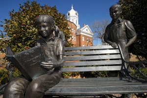 Statue di bronzo collocate sul terreno del tribunale della Contea di Monroe. La ragazza legge il libro "To Kill a Mockingbird" di Harper Lee