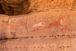 Disegni preistorici che illustrano una scena di caccia sul muro di una grotta a Wadi, Libia