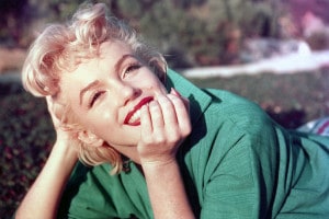 L'attrice Marilyn Monroe posa per un ritratto sdraiata sull'erba nel 1954 a Palm Springs, in California