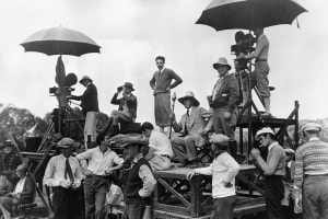 David Wark Griffith (l'uomo seduto in giacca e cravatta) e la sua troupe sul set di un film nel 1915 circa