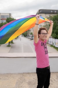 La foto ritrae un giovane che sventola la bandiera arcobaleno, simbolo del movimento LGBT