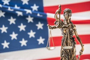 La statua della dea della giustizia e la bandiera americana sullo sfondo