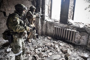 Due soldati russi pattugliano il teatro d'arte drammatica di Mariupol, bombardato il 16 marzo 2022