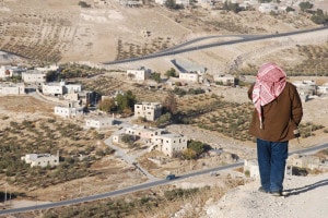 Un uomo in piedi sopra un villaggio alla periferia della città di Betlemme, in Cisgiordania